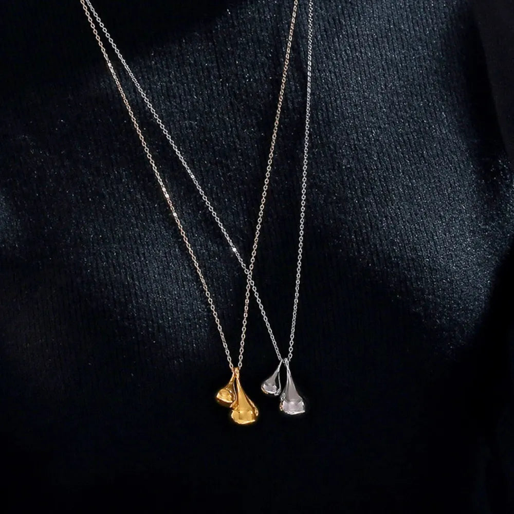 Gold and silver necklaces with sculptural, polished teardrop pendants on delicate chains.