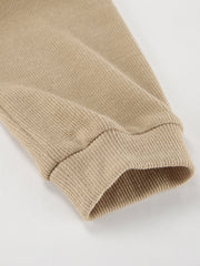 Beige ribbed knit cuff detail on a cowl-neck turtleneck and pants set.