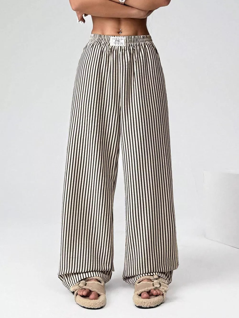 Navy striped high-waisted wide-leg pants with drawstring detail.