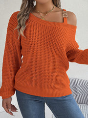 Orange one-shoulder knit sweater with buckle detail and waffle texture.