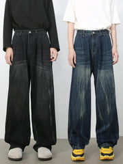 Pleated wide-leg distressed denim trousers in dark and medium wash, featuring a relaxed fit.