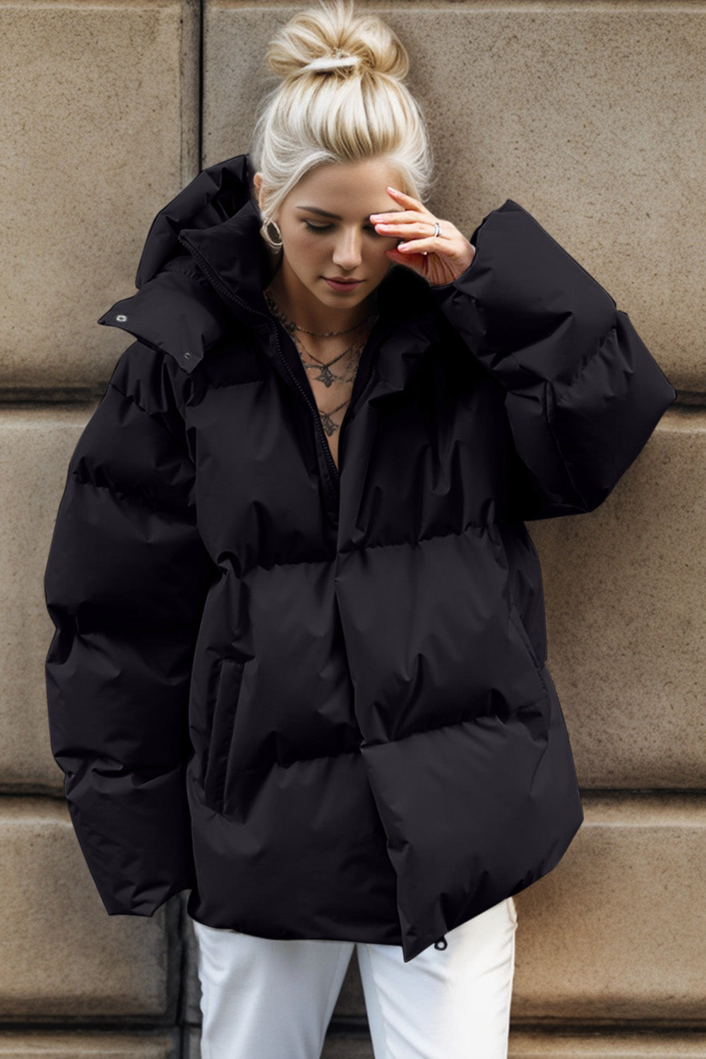 Black oversized puffer jacket with hood and large pockets.