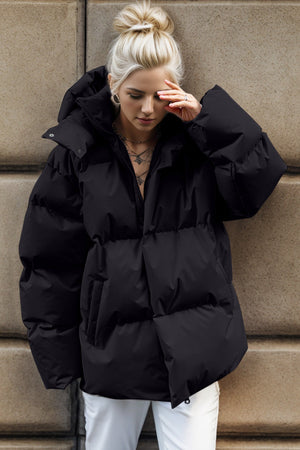 Black oversized puffer jacket with hood and large pockets.