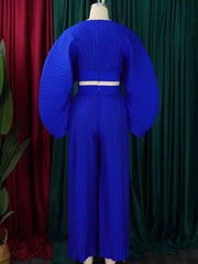 Royal blue pleated two-piece set with wide leg pants and dramatic sleeves.