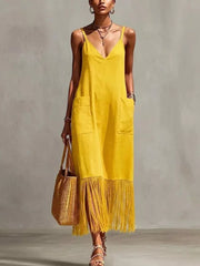 Yellow maxi dress with V-neck, spaghetti straps, pockets, and fringe hem detail.