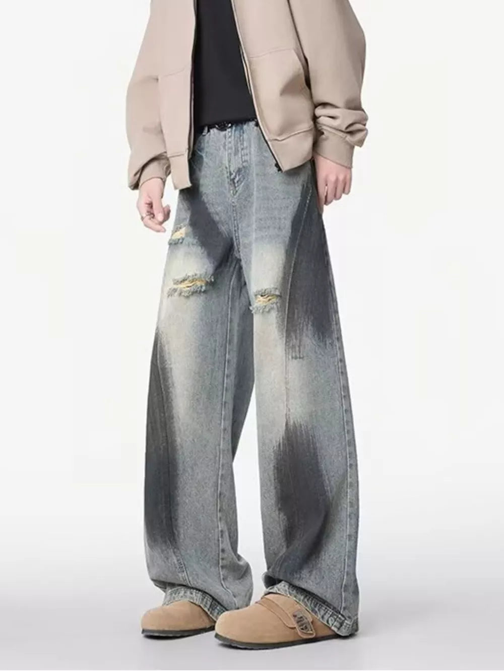 Distressed wide-leg jeans with belted detail in light wash denim, featuring ripped accents and a gradient effect.