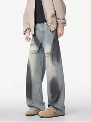 Distressed wide-leg jeans with belted detail in light wash denim, featuring ripped accents and a gradient effect.