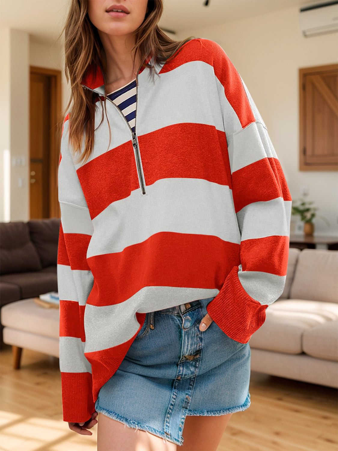 Oversized zip-up pullover with bold orange-red and white stripes, ribbed cuffs, and a contrast striped undershirt.