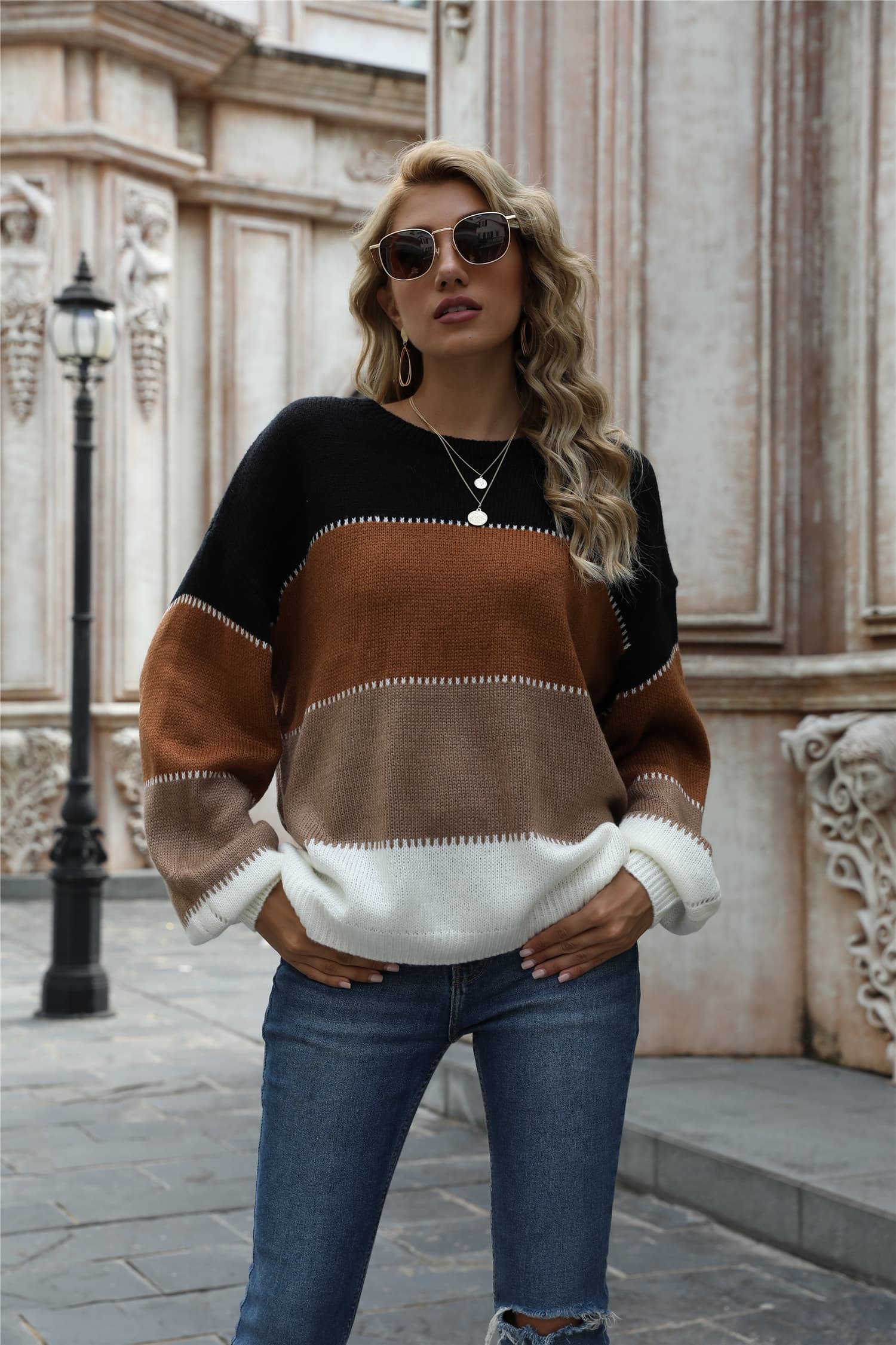Crewneck knit sweater with horizontal color blocks in black, brown, tan, and white acrylic.