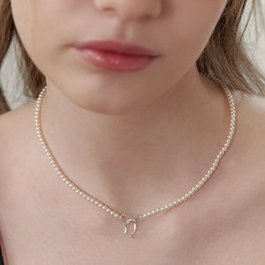 Silver pearl choker necklace with a delicate bow pendant.
