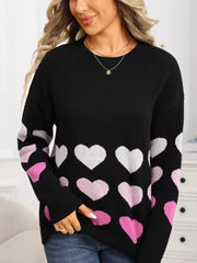 Black crew neck sweater with allover pink and white heart print and ribbed cuffs.