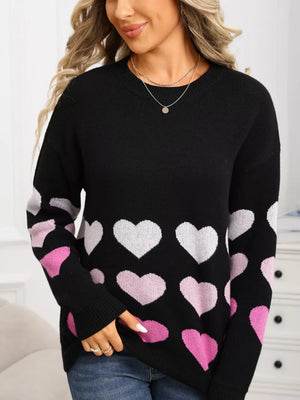 Black crew neck sweater with allover pink and white heart print and ribbed cuffs.