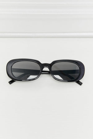 Black oval sunglasses with dark tinted lenses and a glossy finish.