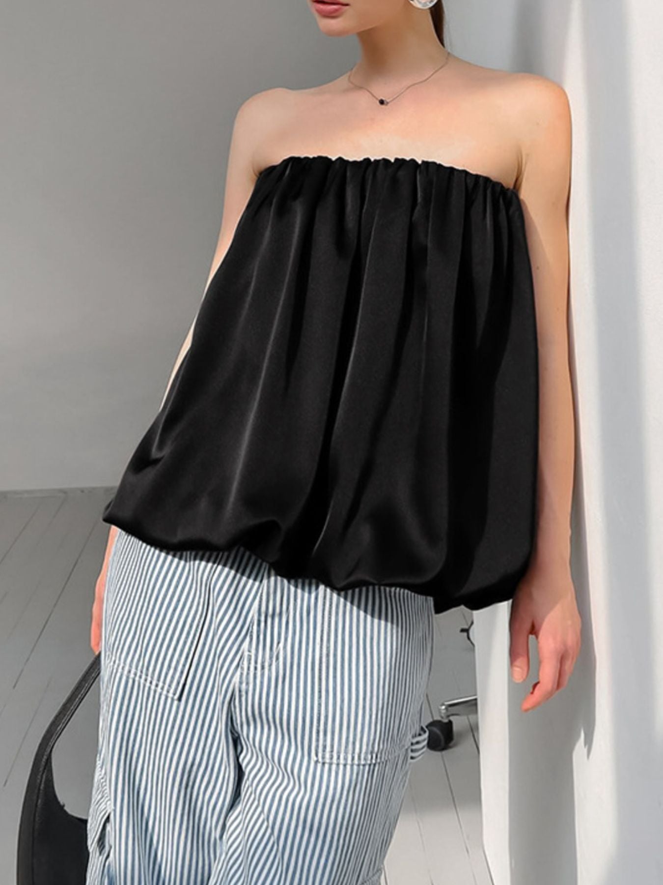 Black strapless bubble hem top with gathered neckline and cinched hem