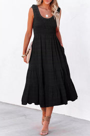 Black smocked tiered midi dress with pockets and square neckline.