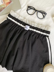 Black mini skirt with lace trim, gathered waist, and white side stripes.