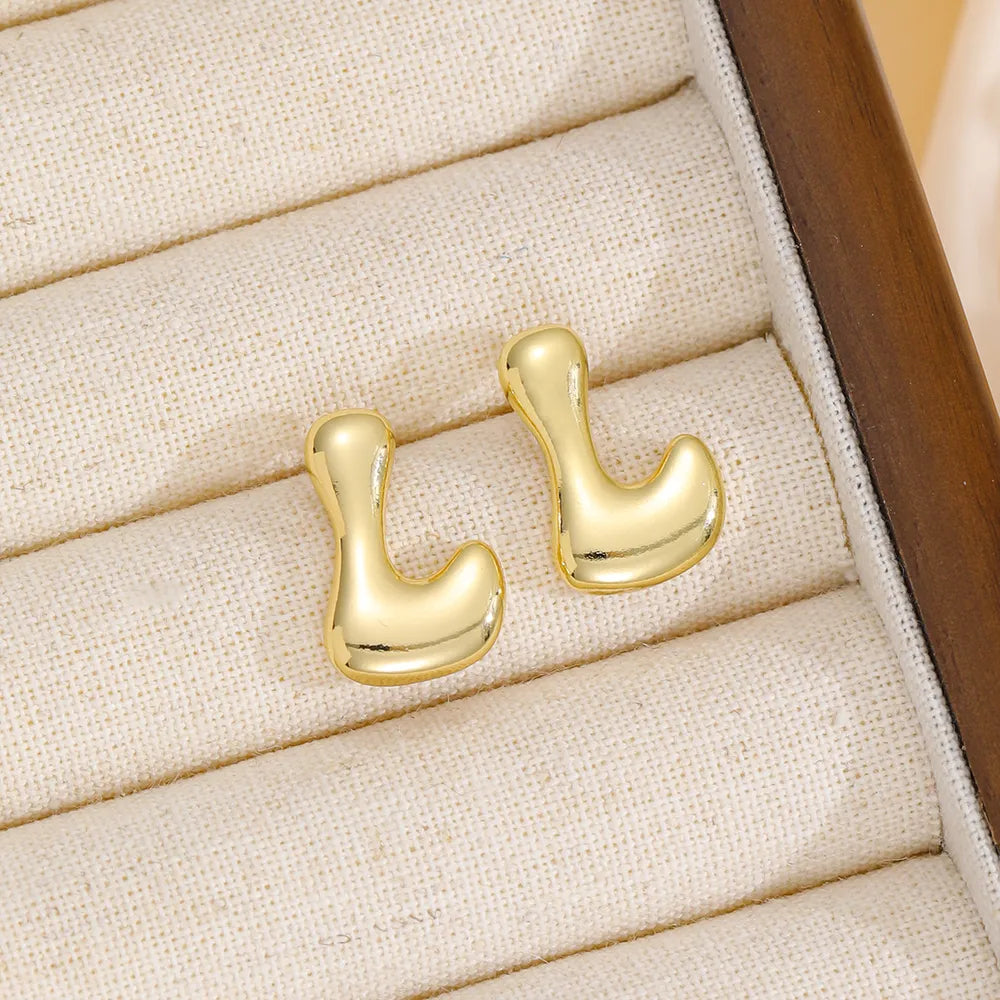 Gold sculptural stud earrings in the shape of the letter L