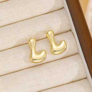 Gold sculptural stud earrings in the shape of the letter L