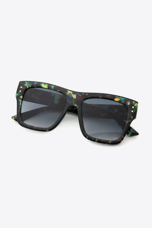 Prismatic square frame sunglasses with dark lenses and gold stud details.
