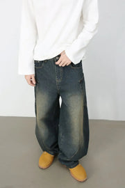 Sculpted denim balloon trousers in dark wash with a relaxed fit and visible stitching details.