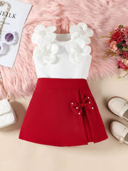 Red skort set with white floral applique top and pearl bow detail.