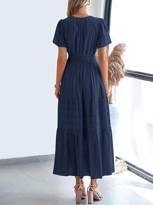 Dark navy tiered maxi dress with smocked waist and short puff sleeves.