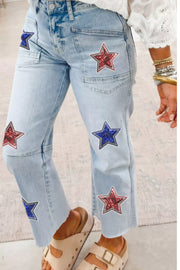 Light wash denim cropped jeans with red and blue sequin star patches and utility pockets.