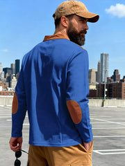 Blue long-sleeve men's t-shirt with brown elbow patches and collar detail.