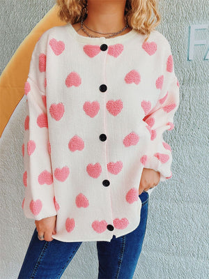 White acrylic button-down cardigan with textured pink heart motif and black buttons.