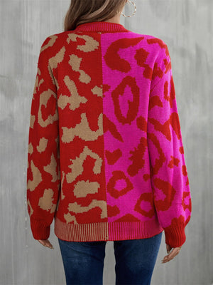 Split leopard knit sweater with statement sleeves in rose/red and blue/green color-blocked design.