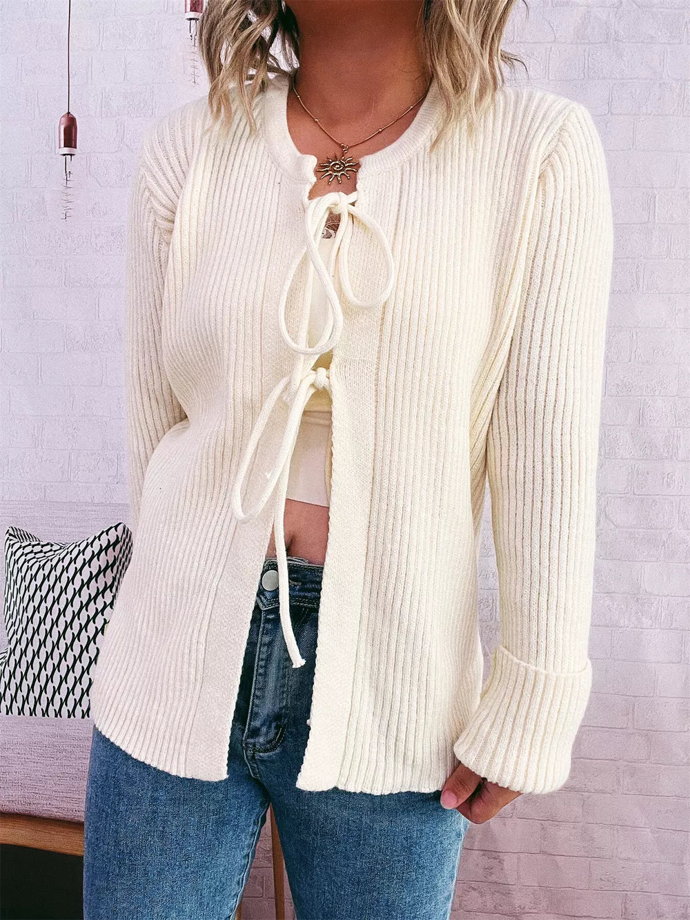 Ivory ribbed tie-front cardigan with cuffed sleeves and a crew neck.