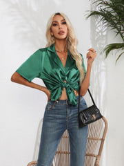 Emerald green satin collared shirt with short sleeves, tied at the waist.