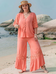 Coral viscose jumpsuit with lace sleeves and hem, V-neck, button front, wide leg pants.