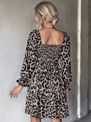 Smocked bodice leopard print mini dress with square neckline and ruffled cuffs.