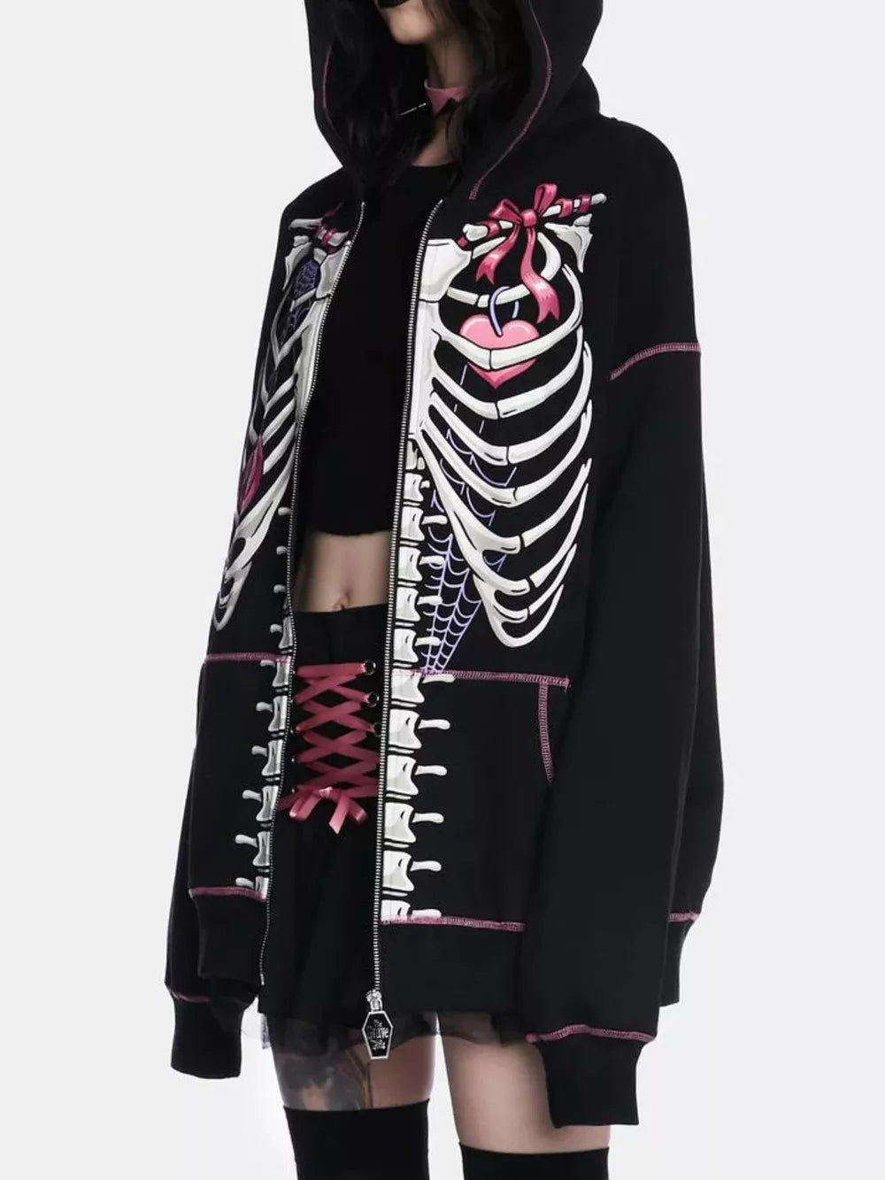 Black zip-up hoodie with playful skeleton graphic, pink stitching, and drawstring hood.