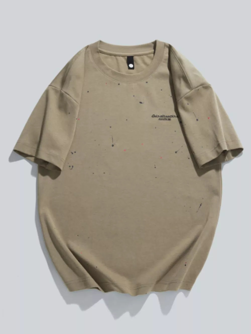 Men's tan cotton t-shirt with artistic paint splatter detail and text graphic.