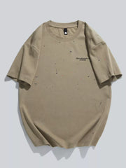 Men's tan cotton t-shirt with artistic paint splatter detail and text graphic.