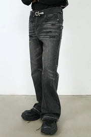 Distressed flare jeans in washed black denim with a bootcut leg and frayed hem detail.