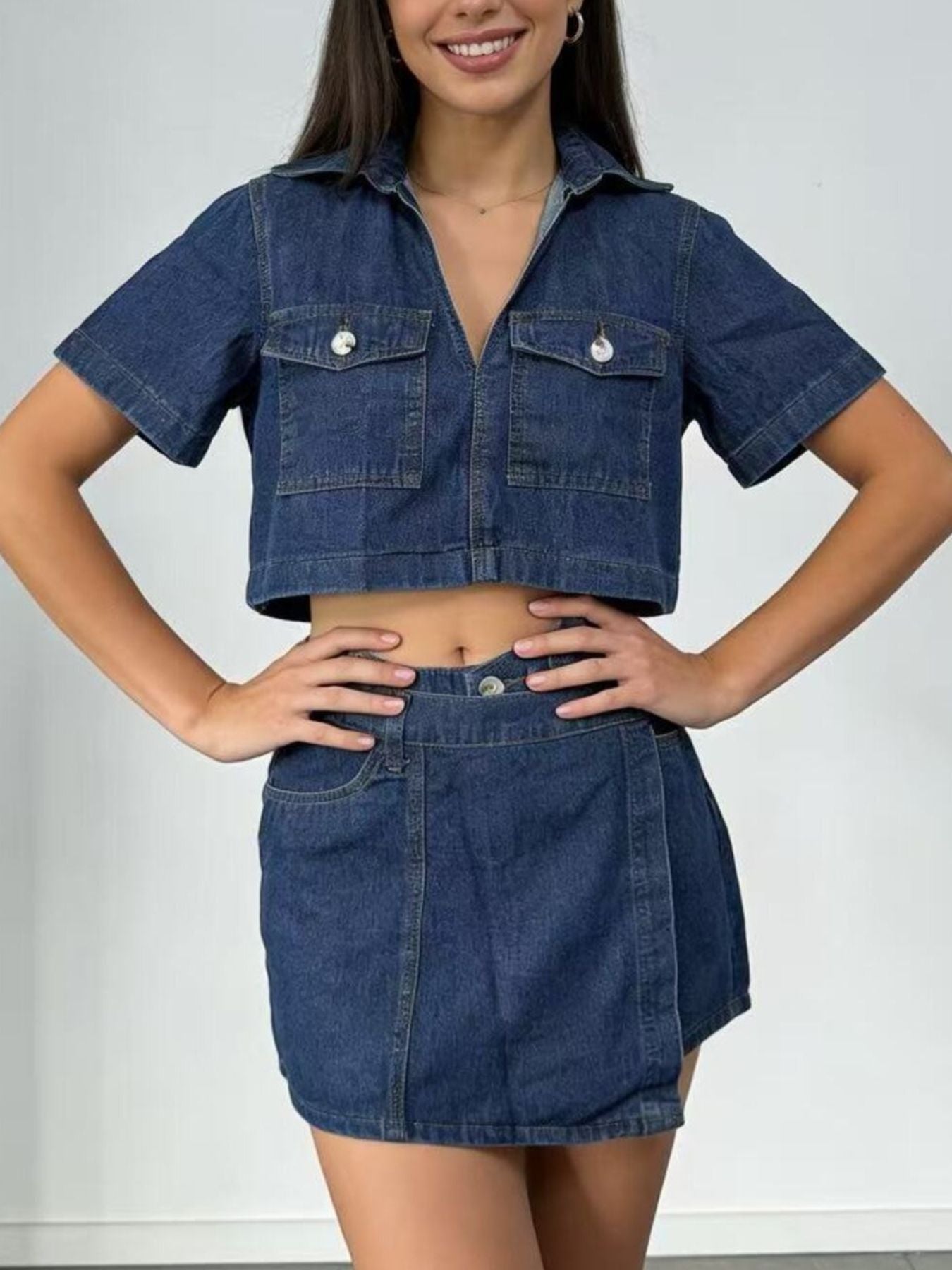 Medium wash denim cropped button-down top and mini skort set with dual chest pockets.
