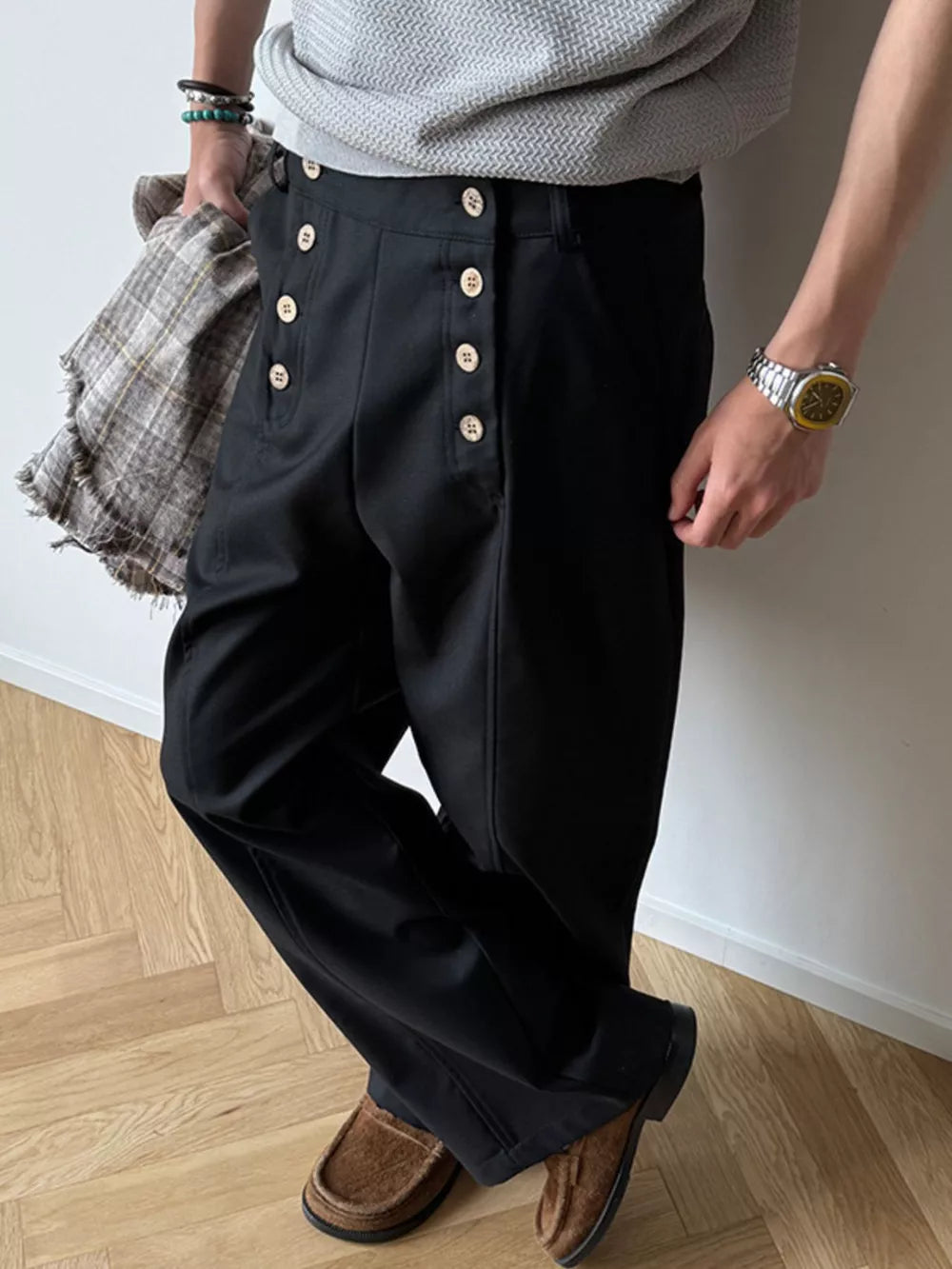 Black high-waisted wide leg pants with button detail and a relaxed fit.