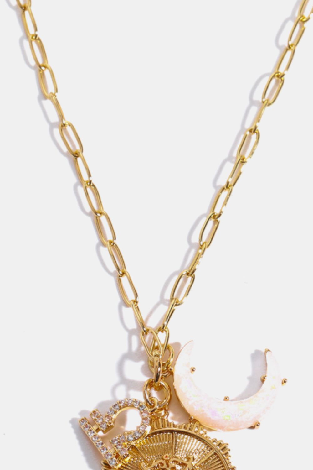 Gold chain pendant necklace with Libra zodiac sign, celestial moon, and sun charms.