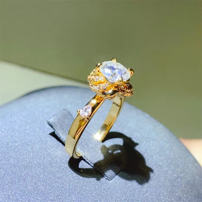 Gold statement ring with floral halo moissanite and pear-shaped accent stones.