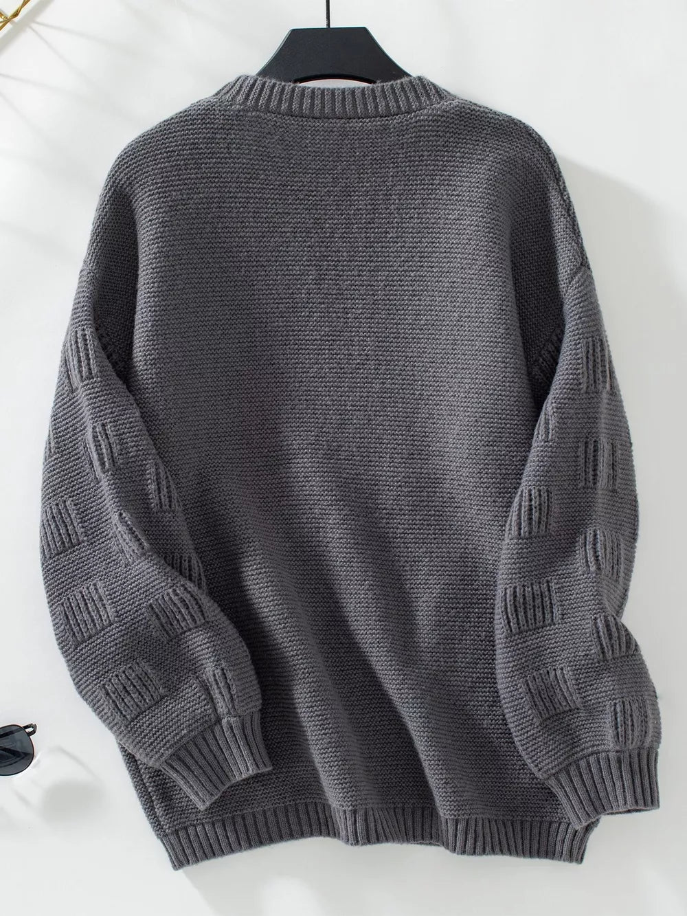 Dark gray chunky knit cardigan with textured sleeves and ribbed cuffs.