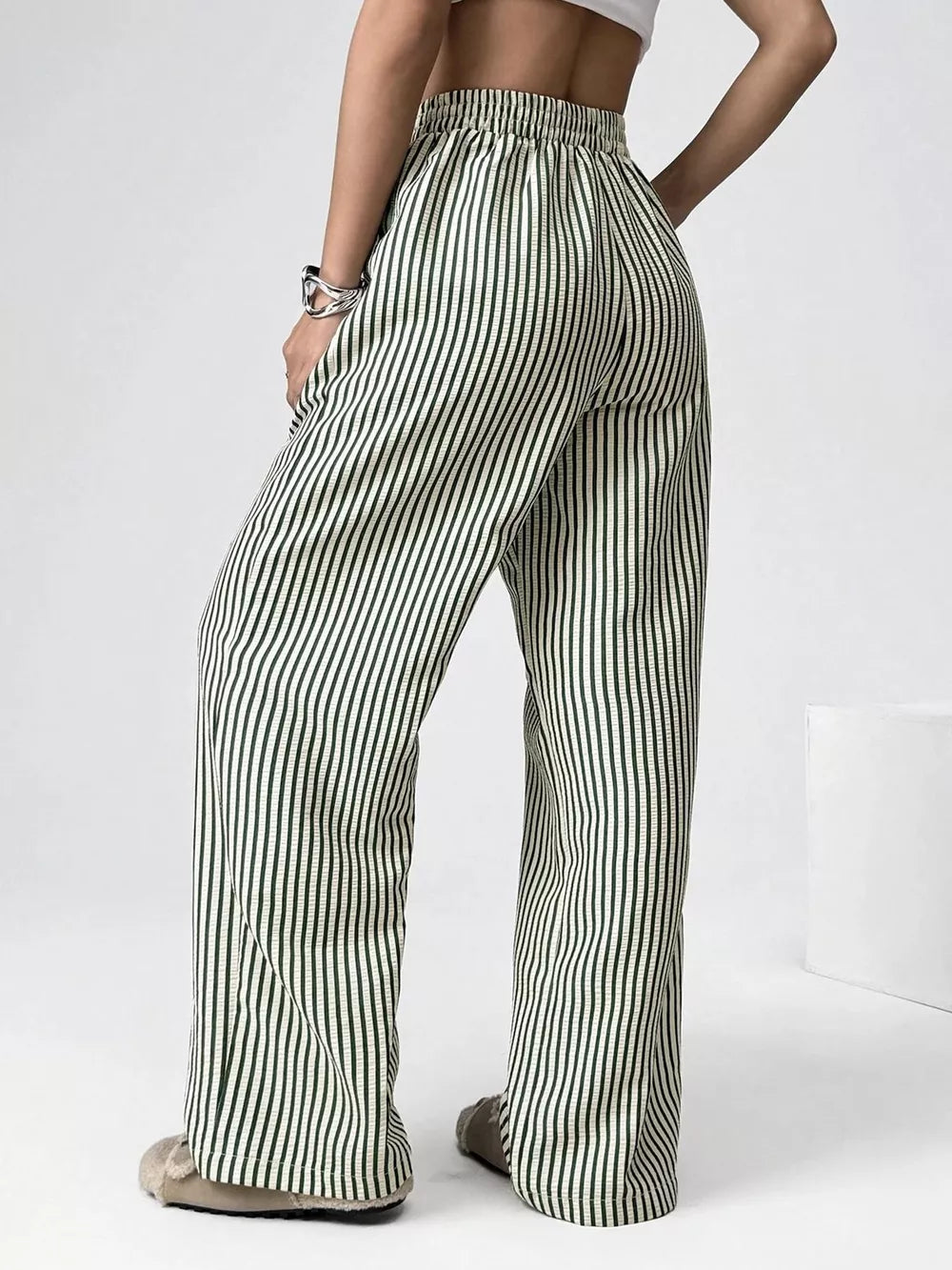 Green striped high-waisted wide-leg pants with drawstring detail.