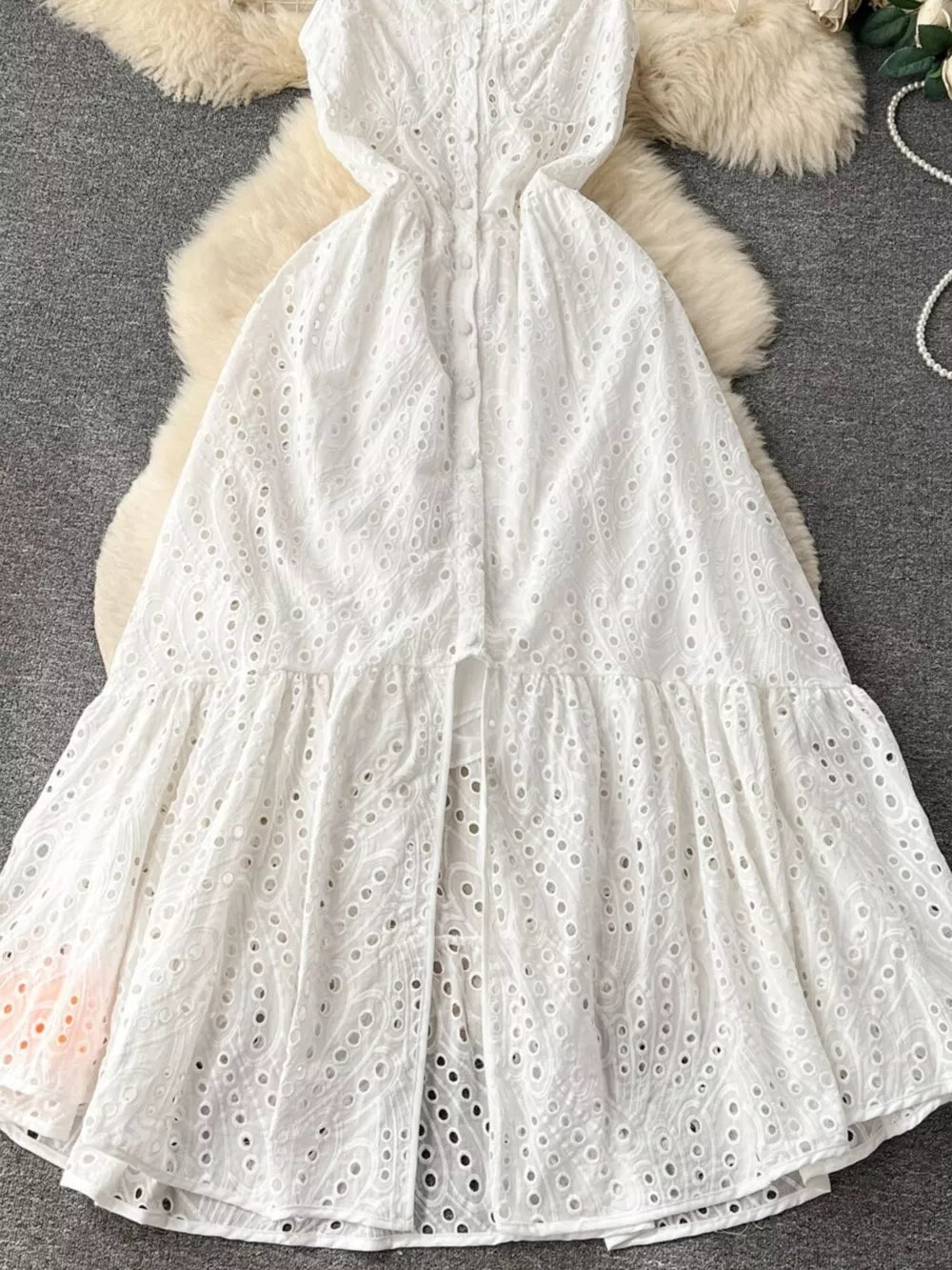White lace-embroidered cami dress with tiered skirt and button front detail.