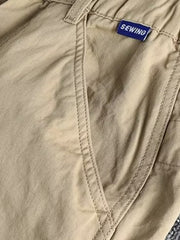 Khaki cargo pants with elastic waist and button closure, featuring a SEWING brand tag.