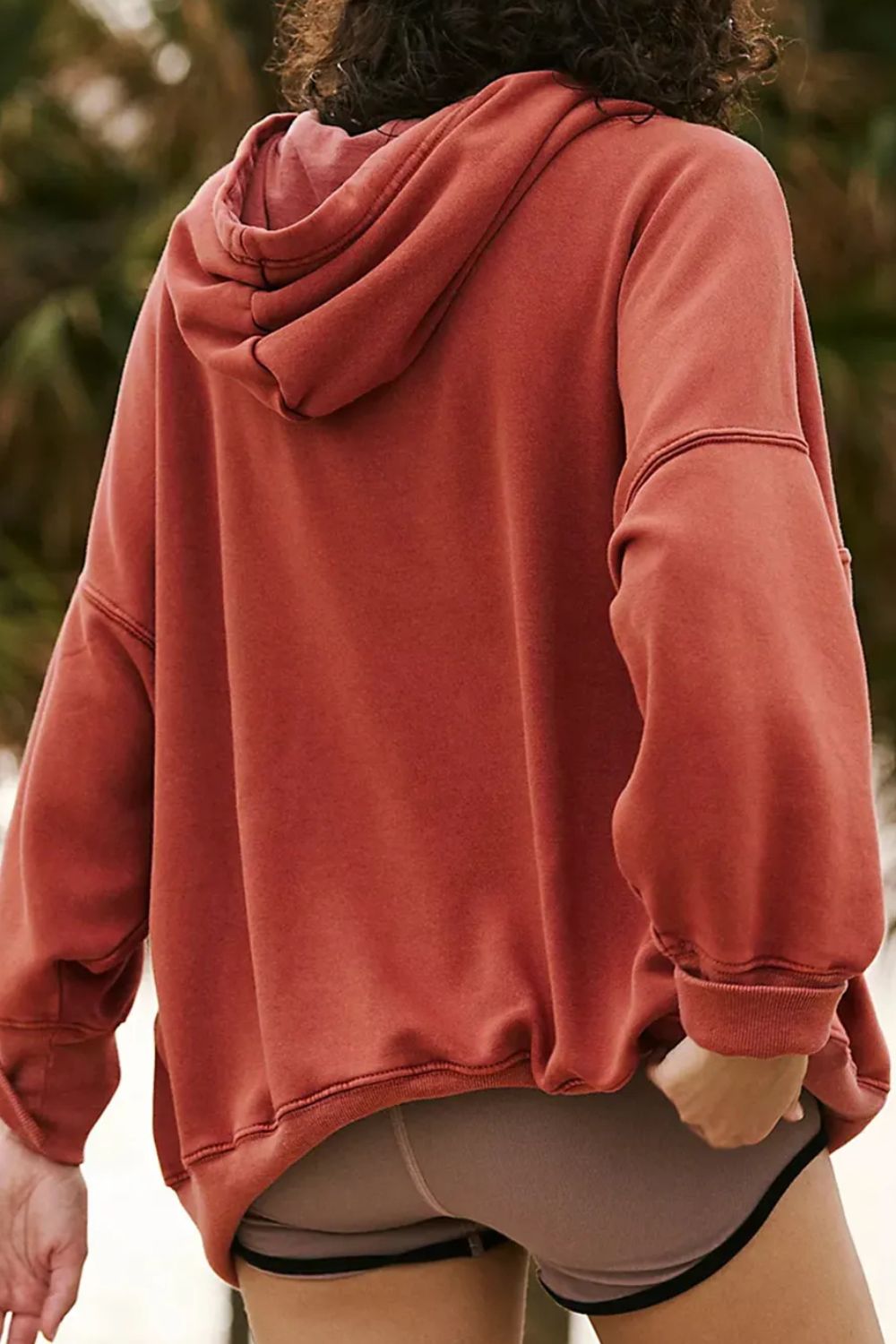 Oversized rust washed cotton hoodie with a relaxed fit and visible stitching details.