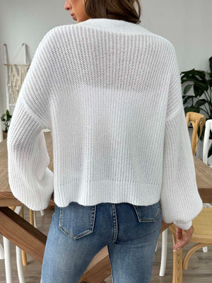 White balloon sleeve cardigan with a textured knit and button front, styled with jeans.