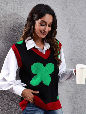 Black acrylic knit vest with green clover intarsia pattern and red trim.