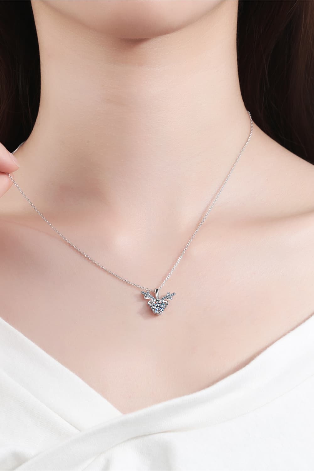 Silver reindeer pendant necklace with moissanite on a delicate chain.